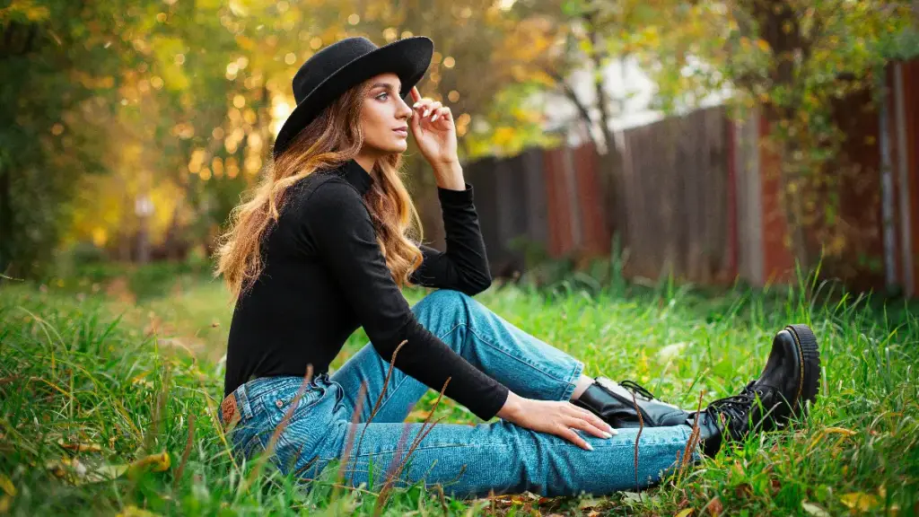 a woman in denim jean sitting on the grass