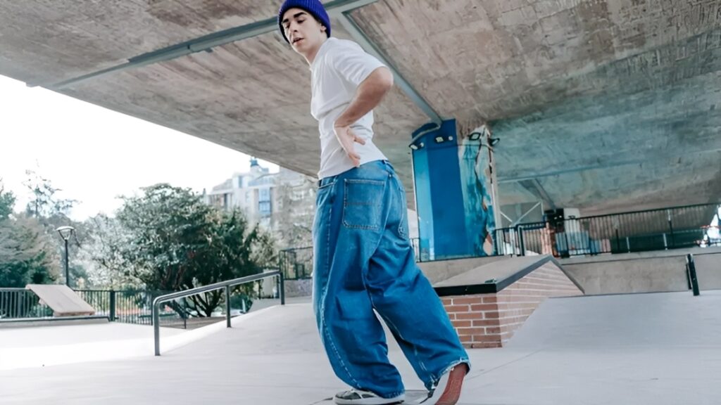 a young man riding a skateboard under a bridge