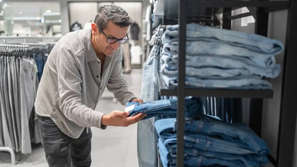 a man is shopping denim jeans in the store