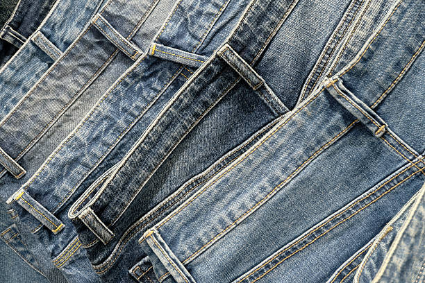 A stack of blue stonewashed jeans, close up shot, abstract textile industry background