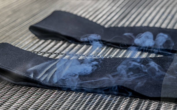 Close up on some jeans at a factory ripped with a laser machine fashion industry concepts