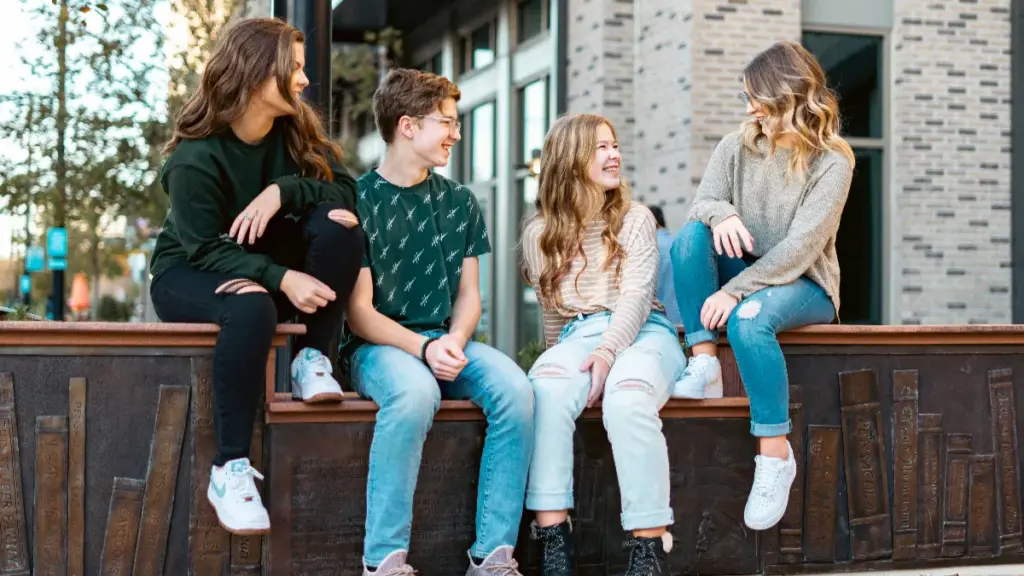 a group of young guys in dark or light wash denim jeans sitting on the ground