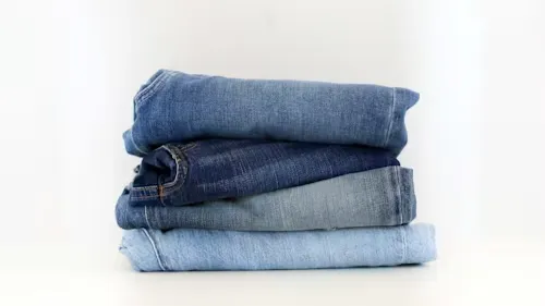 A Stack Of Denim Jeans Sitting On Top Of Each Other